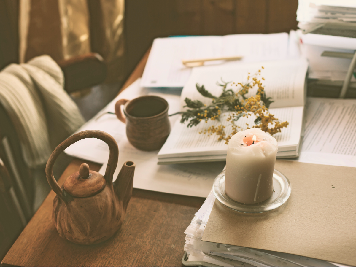 Desk with a mug, candle, and holistic items, symbolizing a curated collection of safe, non-toxic, and fair trade products.